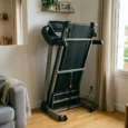 Tapis de marche pliable petit espace rangé debout près d’un mur dans un salon lumineux.
